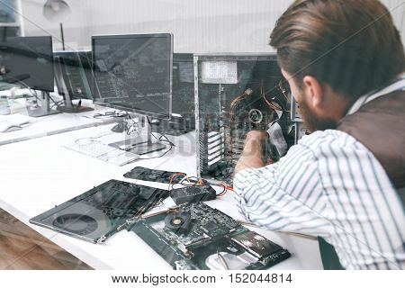 Electronic repairman working with CPU, double exposure. Unrecognizable engineer disassembling computer unit in repair shop