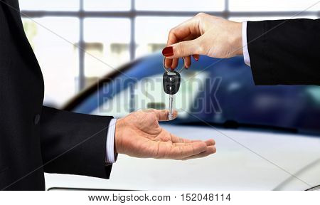 Car key handover by the sales person at showroom