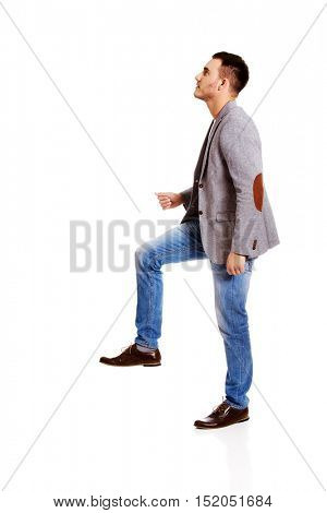 Side view of a businessman climbs the stairs