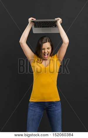 Angry woman trowing her laptop into the floor
