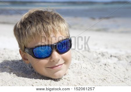 Boy on holiday buried in the sand
