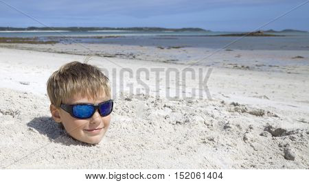 Boy on holiday buried in the sand