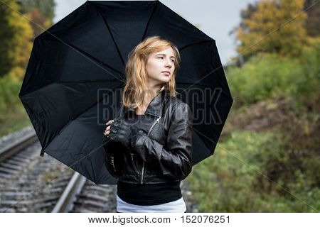 Girl, Umbrella And Rails In Autumn Day