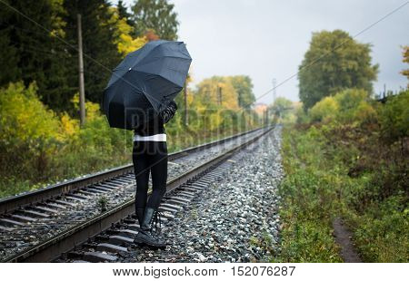 Girl, Umbrella And Rails In Autumn Day