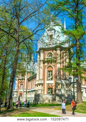 MOSCOW RUSSIA - MAY 10 2015: The side wall of the Grand Palace of Imperial Residence in Tsaritsyno is hidden behind the green branches of the trees on May 10 in Moscow.