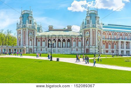 MOSCOW RUSSIA - MAY 10 2015: The facade of the Grand Palace of Tsaritsyno Royal Residence decorated with towers patterns fretwork and surrounded by lawn on May 10 in Moscow.