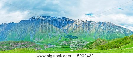 The slopes of Kazbegi National Park are the perfect place to overlook Stepantsminda resort lying in the mountain valley Gergeti Georgia.