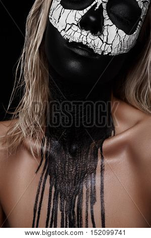 Death Woman Halloween Makeup. Black painted Face and Neck, white Clay Skull