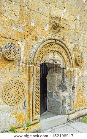 The entrance to Tsminda Sameba (Holy Trinity) Church decorated with the medieval rosette carved patterns Gergeti Georgia.
