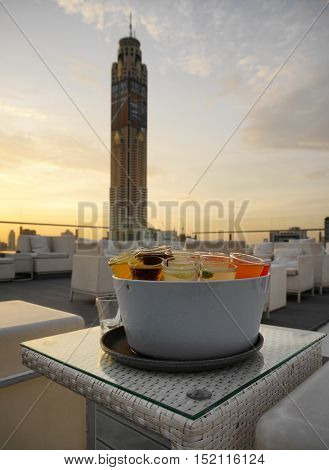 various cocktail shot course serve in ice bucket in evening twilight time with blur focus of open air rooftop bar  - soft focus,sihouettes