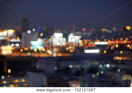 bird eye view  blur photo with bokeh light of high building, high way road, bill board and car in the dark night time