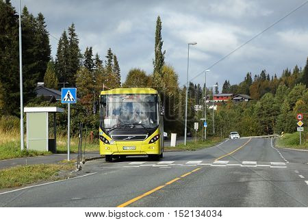 Tanem Norway - September 26 2015: Bus operated by Atb on line 47 with destination Trondheim at a bus stop in fron of a pedestrian crossing on road 704 in Tanem village.