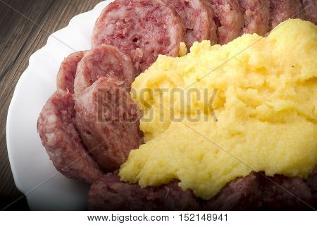 pork sausage (cotechino) with polenta on the wood table