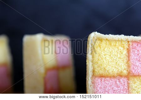 Freshly Cut Battenberg Cake Slices With Dark Background. Pink And Yellow Sponge Covered In Marzipan