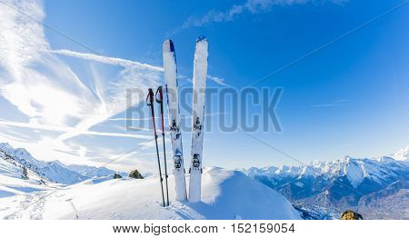 Ski in winter season, mountains and ski touring equipments on the top at sunrise.