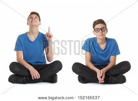 Cute teenager boy poinitng up in blue T-shirt and lotus posture over white isolated background