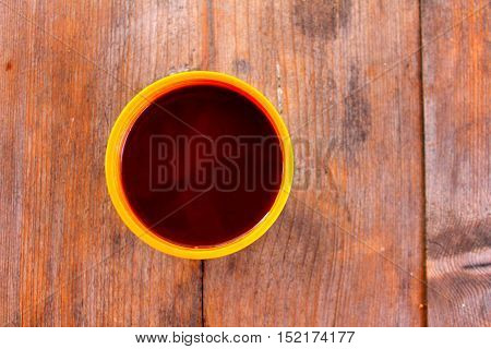 A cup with a hot drink on a wooden table outdoors