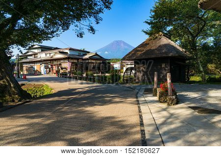 Oshino, Japan - September 2, 2016:Oshino Hakkai Fuji Five Lakes. Japan countryside street with historic thatch roof farmhouses and Mt Fuji on the background