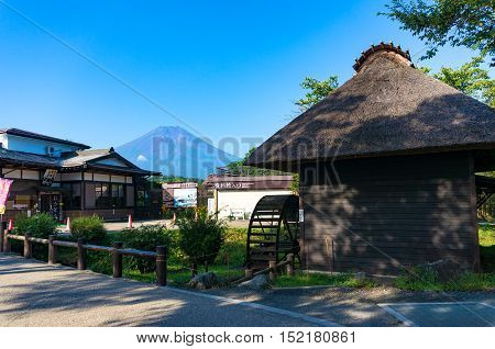 Oshino, Japan - September 2, 2016:Oshino Hakkai, Fuji Five Lakes. Japan countryside street with historic thatch roof farmhouses and Mt Fuji on the background