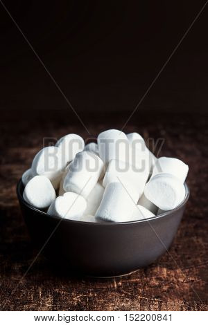 Heap of white marshmallow on wooden table with copy space