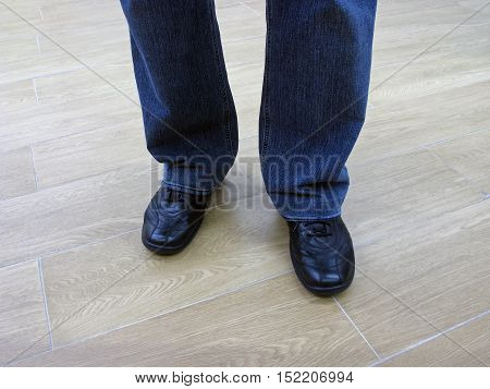 Man stands in jeans and in casual shoes. Man in jeans and everyday shoes. Man in jeans and casual shoes. Male legs in jeans and boots.