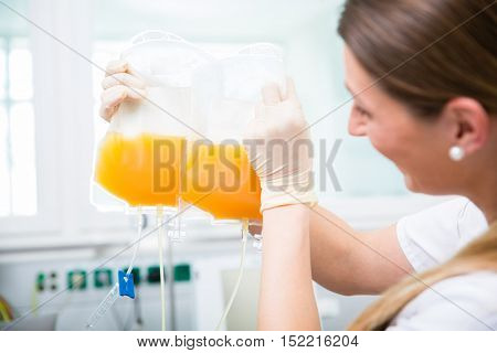 Doctors assistant at blood donation service with plasma donation in blood bag