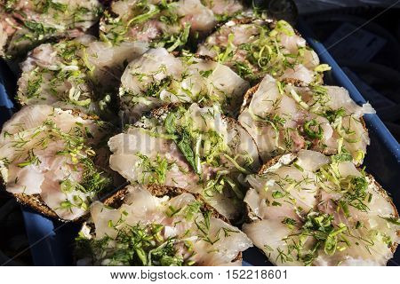 fresh marinated scandinavian herring fillet mini sandwich snacks with dill in helsinki market