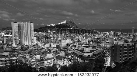 Aerial night view of Alicante Costa Blanca Spain. Old city center with harbor illumination. Santa Barbara Castle located on Mount Benacantil. Black and white