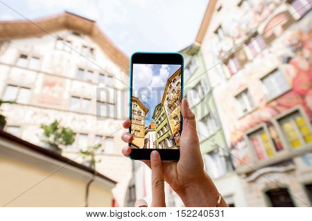 Photographing with smart phone old colorful buildings in the old town of Lucerne city in Switzerland