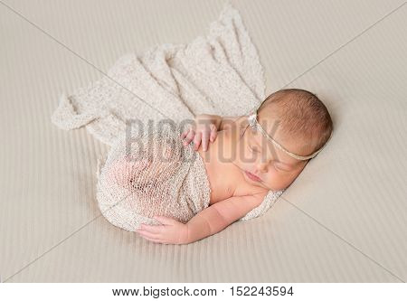 lovely smiling sleeping infant wrapped in gray warm diaper
