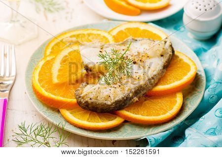 Orange Halibut Steaks on blue plate.seletive focus