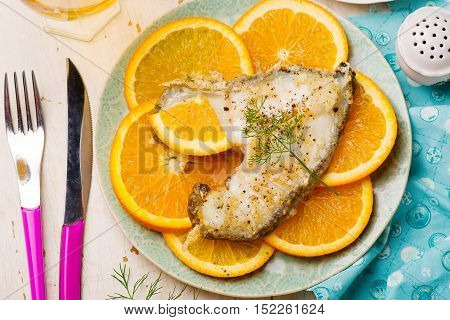 Orange Halibut Steaks on blue plate.seletive focus