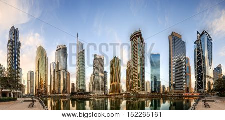 Panoramic view of Business bay and Lake Tower, reflection in a river, Dubai, UAE.