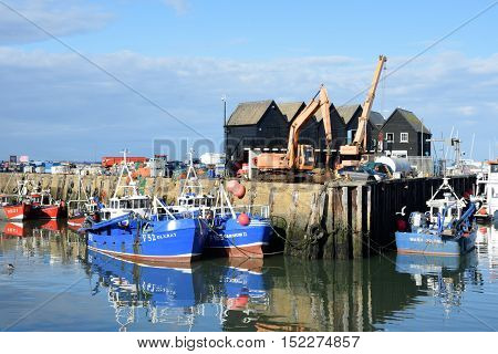 Whitstable United Kingdom -October 1 2016: Fishing Boats in Whitstable Harbour with warehouse in background