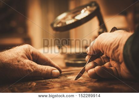 Senior restorer working with antique decor element in his workshop