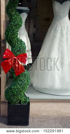 Big red bow and wedding dresses in a shop window