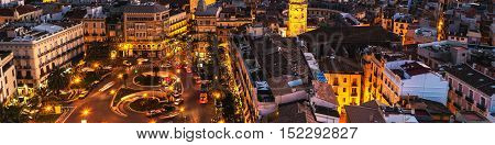 Aerial view of Valencia Spain at sunset. Illuminated Plaza de la Reina with many cafes and restaurants and very popular among tourists. Cloudy colorful sky