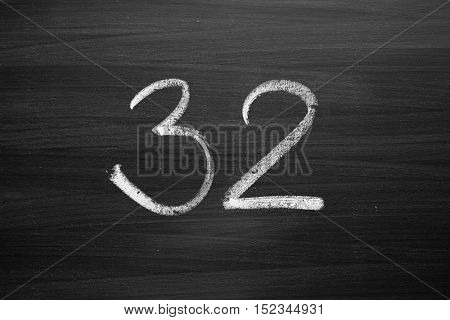 number thirty two enumeration written with a chalk on the blackboard