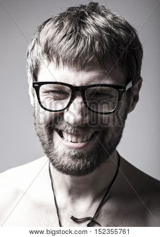 bearded man in glasses plays the fool. crazy man, funny expression.