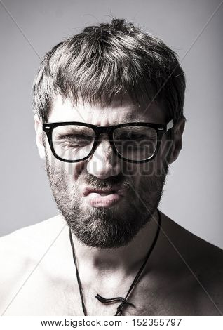 bearded man in glasses plays the fool. crazy man, funny expression.