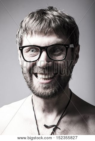 bearded man in glasses plays the fool. crazy man, funny expression.