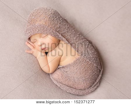 bare sweet sleeping newborn girl covered with knitted shawl