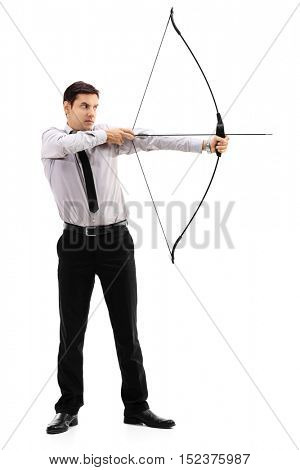 Full length portrait of a young businessman aiming with a bow and arrow isolated on white background