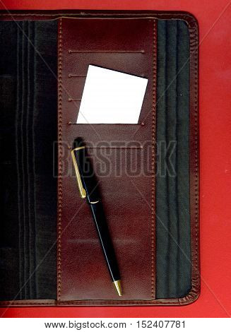 Image of a business card and pen placed on the agenda