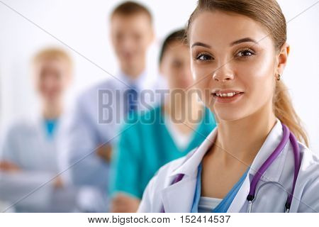 Group of doctors at hospital, focused at female physician.