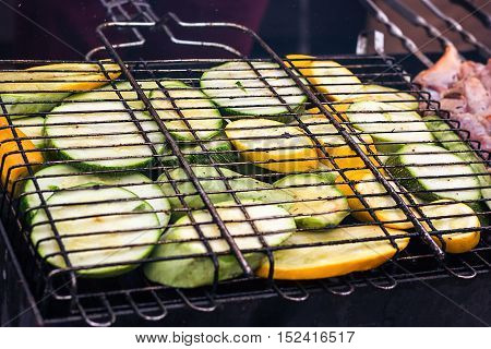 Fresh healthy green yellow zucchini courgettes cucumber preparing on barbecue grill over charcoal. Grilled zucchini slices. Vegetarian, Mediterranean cuisine. Delicious Food, vegetables on bbq party.