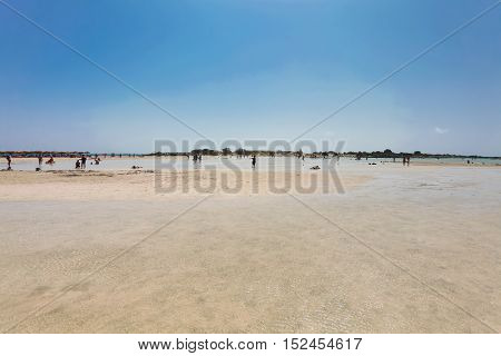 Elafonisi, Island Crete, Greece, - June 26, 2016: Swimming and relaxing people  on the beautiful beach of Elafonisi with pink sand