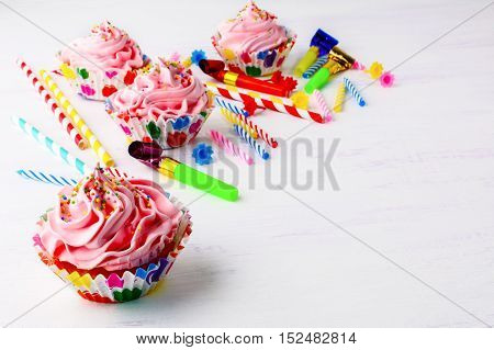 Birthday party background with decorated pink cupcakes and candles. Homemade cupcakes served for party. Birthday card background. Copy space.