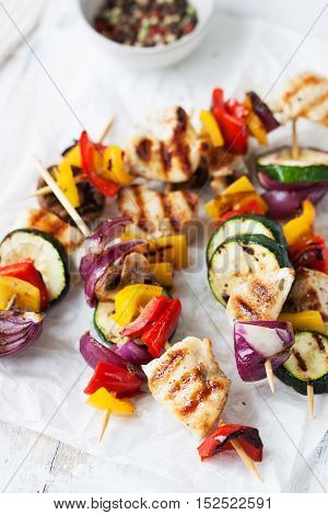 Closeup of chicken skewers or shashlik with grilled vegetables (mushrooms paprika salad zucchini onion)