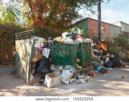 Dumpsters being full with garbage on the street of city